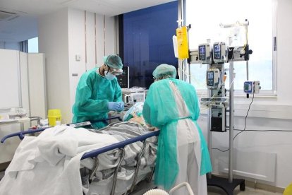 Dos sanitarios atendiendo a un paciente en el hospital de Trueta de Girona.