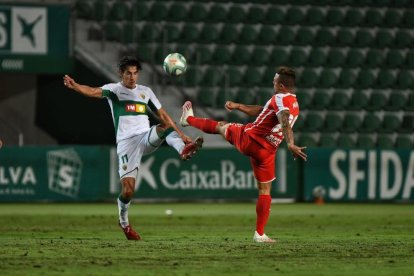 El leridano Pere Milla, jugador del Elche, disputa un balón con el gerundense Maffeo.