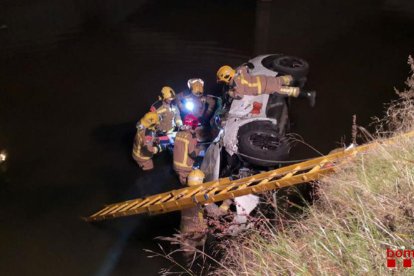 Un grupo de bomberos retirando el vehículo del canal. 