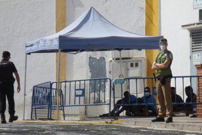 Agents i personal de seguretat custodien alguns dels migrants que van poder saltar la tanca ahir.