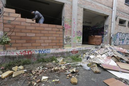 Un operario trabaja en las tareas para tapiar la nave abandonada en Rufea.