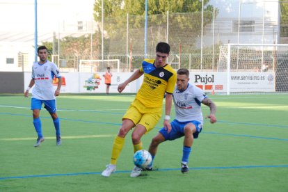 Un jugador del Tàrrega controla la bimba pressionat per un altre del Mollerussa, ahir durant el partit.