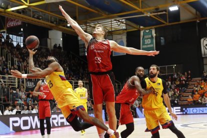 Malcolm Delaney intenta lanzar a canasta ante el bloqueo de Egidijus Mockevicius.