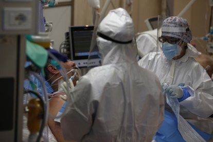 Personal sanitari amb equips de protecció atenen un pacient a l’UCI.