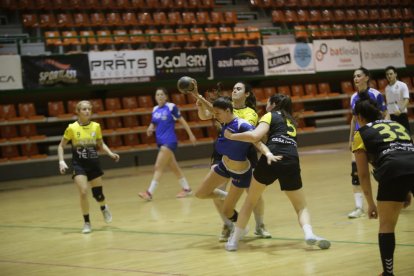 Una jugadora de l’Associació Lleidatana d’Handbol intenta tirar, subjecta per una altra de l’Amposta.