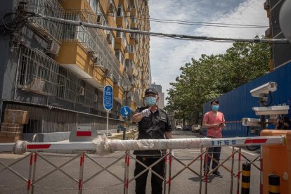 Control policial en un carrer de Pequín per reduir el risc de contagi per coronavirus, ahir.