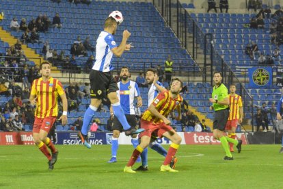 Un defensa de l’Hèrcules rebutja la pilota davant de Pedro Martín.