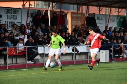 Un jugador del Alpicat intenta progresar por la banda ante la presión ejercida por un jugador del Artesa de Segre.