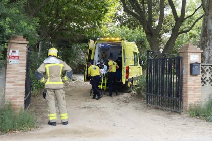 Sanitaris atenent ahir el ferit per inhalació de fum.