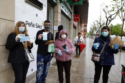 Ciudadanos mostrando las mascarillas que ayer consiguieron en una farmacia de Lleida.