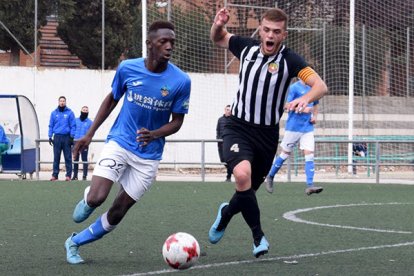 Un jugador del Lleida, con el balón, perseguido por otro del Jàbac.