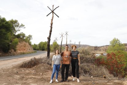 El artista Marc Sellarès y dos de las impulsaras de Camí de Cendra junto a la obra ‘Estels’ en la C-12.  