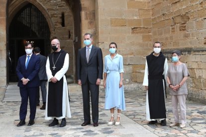 A la izquierda, los reyes en Poblet con Illa y Cunillera. A la derecha, los Mossos impidieron que los manifestantes se acercaran al monasterio. 