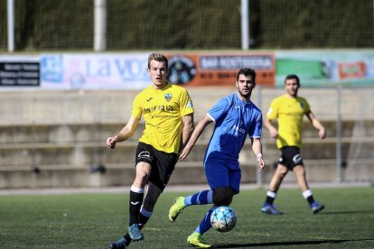 Un jugador del Lleida B conduce el balón ante la presión de un defensa rival.