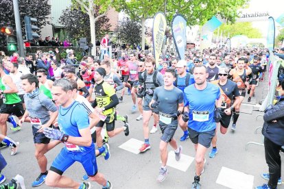 Alguns atletes durant el pas de la Mitja Marató pel pont Vell.