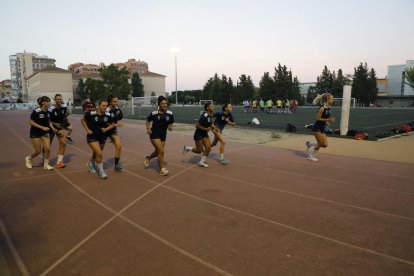 Les jugadores de l’Associació, ahir a la pista del Camp Escolar. Al fons, un equip de futbol.