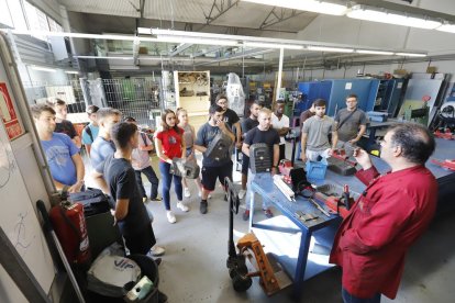 Alumnes d’un cicle de la branca industrial de l’institut Guindàvols, atenent les explicacions d’un professor.