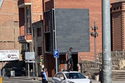 Vista de l'individu pujat ahir a sobre d'un vehicle particular i els agents mirant de reduir-lo.