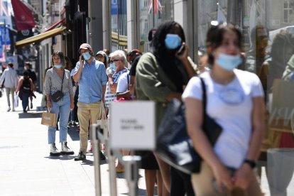 Varias personas hacen cola en Londres para entrar a una tienda.