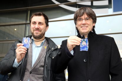 Carles Puigdemont i Toni Comín davant el Parlament Europeu a Brussel·les amb l'acreditació com a eurodiputats a la mà.