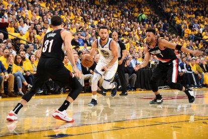 Stephen Curry porta la pilota davant del seu germà Seth.