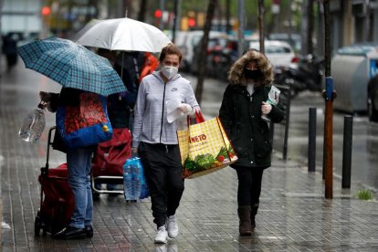 Varias personas ayer en L’Hospitalet, trigésimo octavo día del estado de alarma, tras hacer la compra.