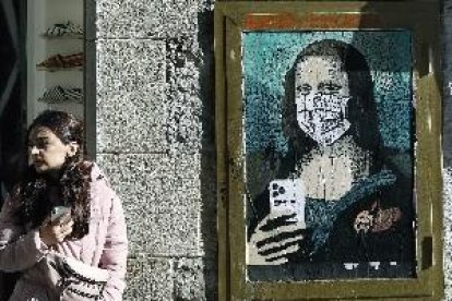 El artista Tvboy retrata en Barcelona a la Gioconda con mascarilla y móvil