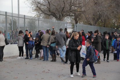 Pares i mares i alumnes a la sortida d'una escola.-