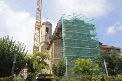 El andamio y la gran grúa instaladas para reparar el tejado de la iglesia de Alpicat.