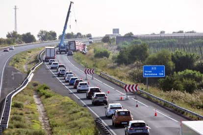 Moment en què les grues treballen per retirar el tràiler accidentat.