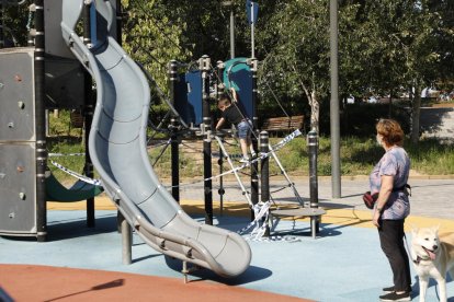 Un nen juga en un parc encara precintat ahir a Lleida.