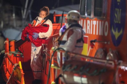 Una miembro de Salvamento Marítimo sostiene a un bebé.