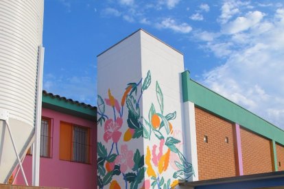 L’artista Lara Costafreda pintant l’exterior de l’escola.