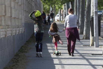 Una mare, a finals del curs passat, al sortir de classe amb dos nenes.