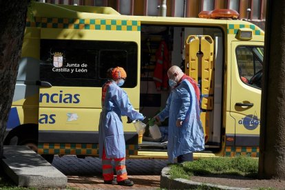 Un equipo de emergencias desinfecta sus elementos de protección después de atender una urgencia en una calle de Ávila