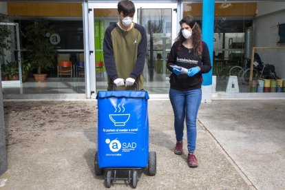 Dos voluntaris transportant el menjar a domicili.