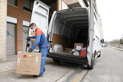 Un repartidor amb màscara i guants entregant un paquet a Lleida.