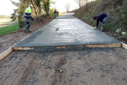 Operaris asfalten un dels camins de Sant Guim de Freixenet.