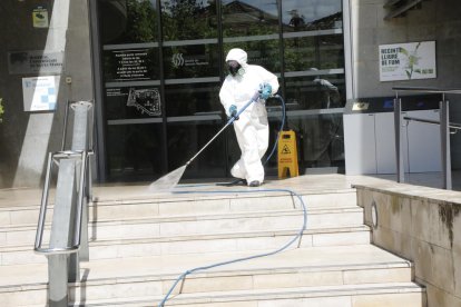 Un operari desinfecta l’entrada de l’hospital Santa Maria.