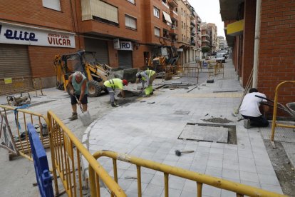 Operaris ultimen les obres de millora d’un tram del carrer les Roses, a la Bordeta.