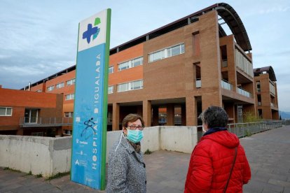 Dos dones amb mascareta davant de l’hospital d’Igualada.