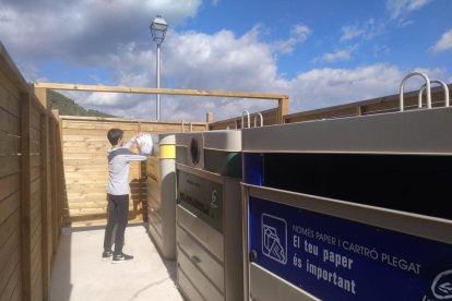 Un niño deposita basura en los contenedores de Tarrés.