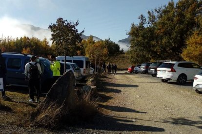 Excursionistas en el parking de la Masieta de Mont-rebei, donde carteles recordaban las medidas de seguridad ante la Covid-19.