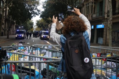 Una mujer lanza una bolsa de basura ante los Mossos.