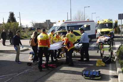 Vista del vehículo, con el impacto en el parabrisas,  y al fondo, la atención de los servicios de emergencias a la viandante herida. 