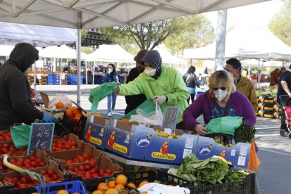 Varios clientes comprando en una parada del mercadillo de ayer en el Barris Nord.