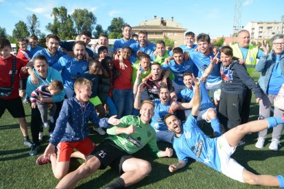 Los jugadores del Alcarràs celebran el campeonato en el césped tras el partido.