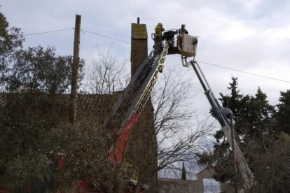 Momento en el que los Bomberos acceden a la cesta para rescatar al operario (i) y mancha de aceite en la fachada de la iglesia (d).