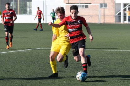 Un jugador del EFAC intenta controlar el balón ante la presión de otro jugador del Tàrrega.