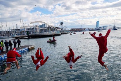 Participants disfressats de Pare Noel es llancen a l’aigua.